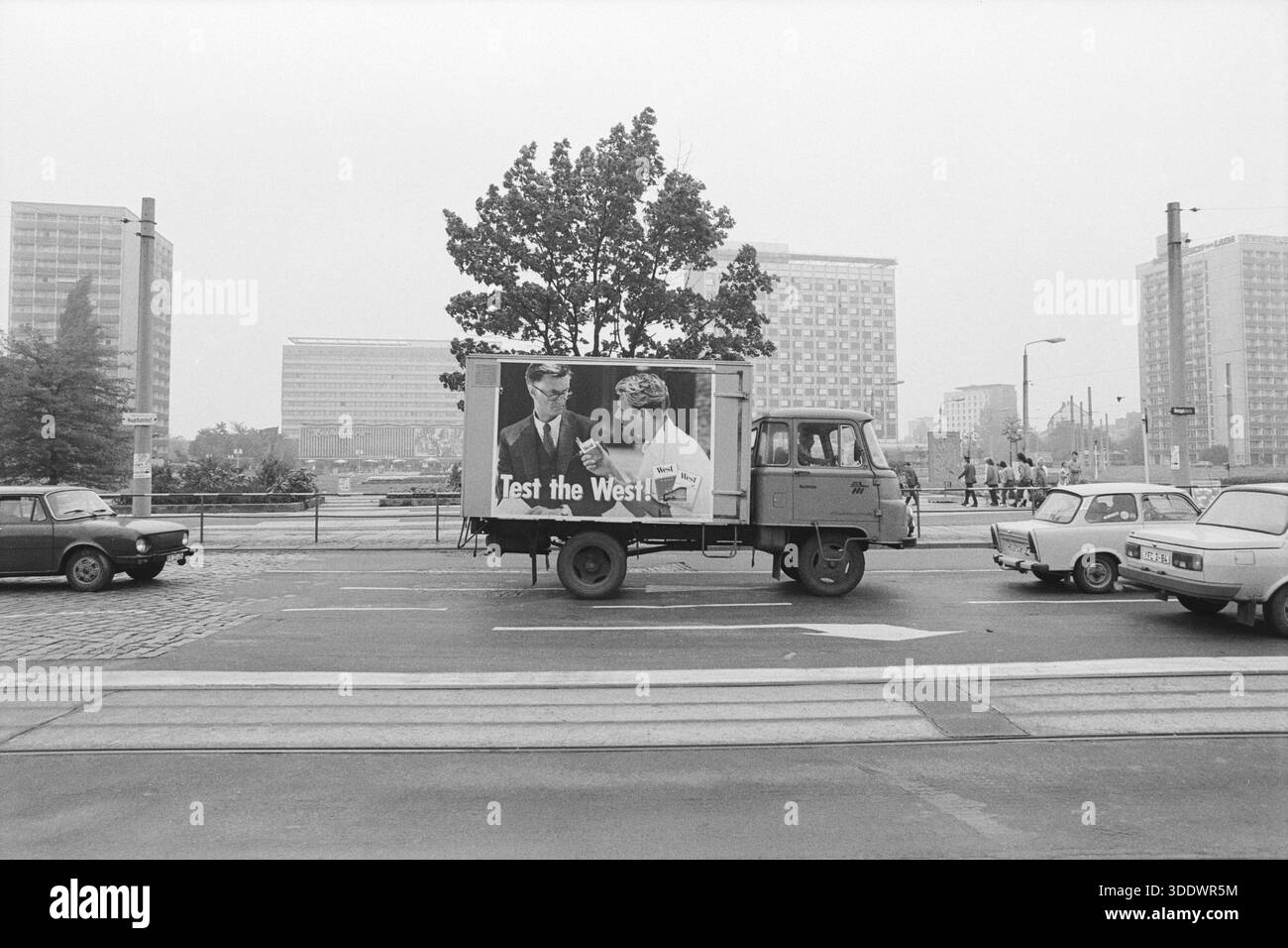 1990 Dresda, Germania: Una fotografia in bianco e nero di un camion in stile sovietico con una pubblicità di sigarette "test the West", che simboleggia la riunificazione e il cul Foto Stock
