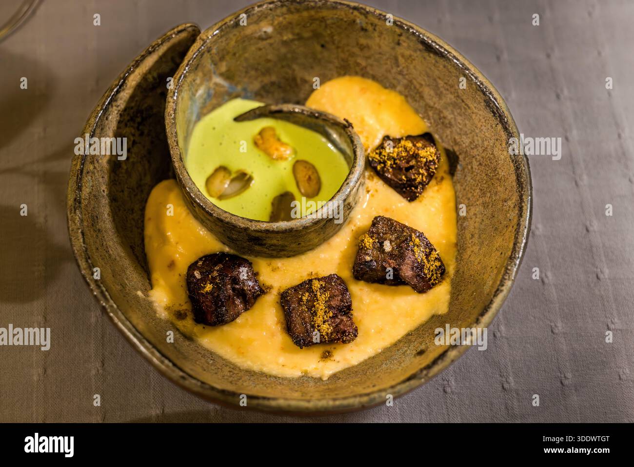 Şüs / Shush è il nome di questo piatto al ristorante Revithia con stella Michelin dell’hotel Kayakapi Premium Caves a Ürgüp, Cappadocia, Turchia: fegato di manzo grigliato e stufato di zampa allo stile Vadabit con fagioli croccanti e una salsa al prezzemolo. Foto Stock