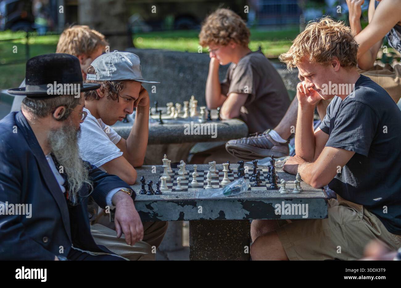 Una vivace partita di scacchi di strada si svolge in un parco di New York City. Foto Stock