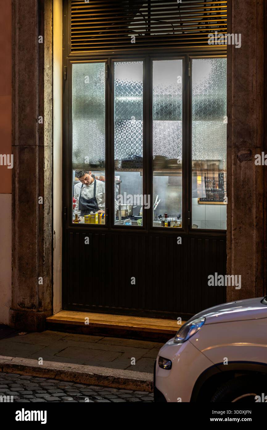 Cuoco che lavora in una cucina di un ristorante a Roma, Italia Foto Stock