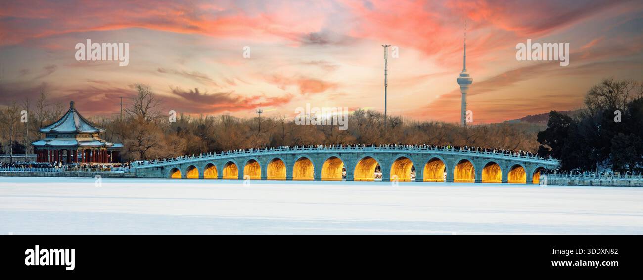 Vista panoramica invernale del Ponte del diciassettesimo arco e del tradizionale padiglione cinese a Pechino al colorato tramonto. Una luce calda si illumina sotto gli archi A. Foto Stock