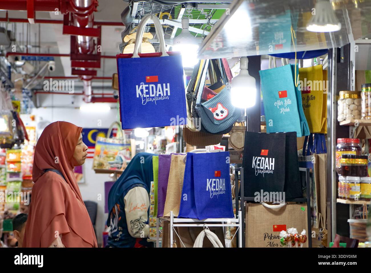 Kedah, Malesia, 5 dicembre 2025: Borse e souvenir colorati con marchi Kedah e Alor Setar esposti in una tradizionale marca malese Foto Stock