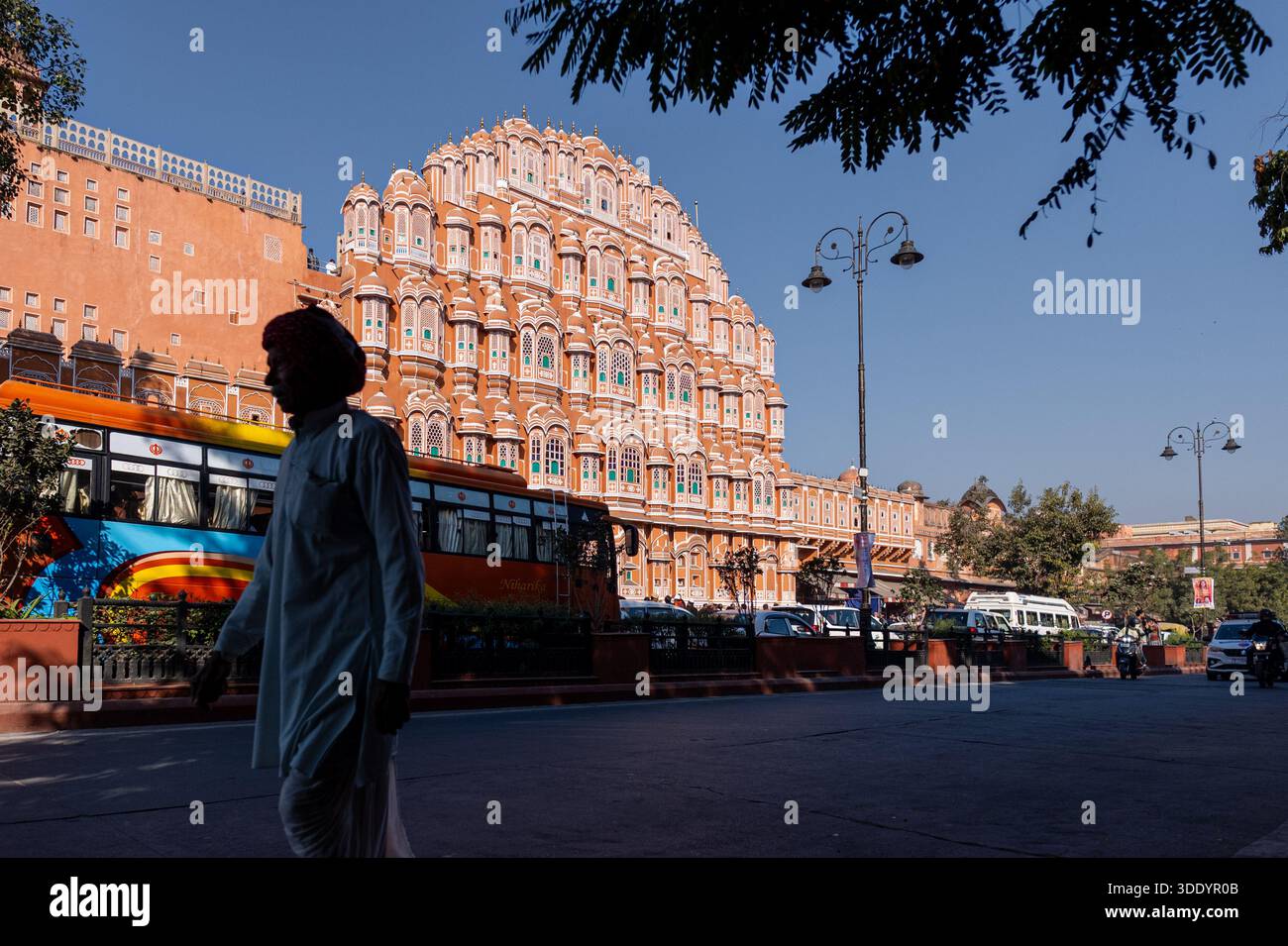 Jaipur, India - 28 dicembre 2025: La facciata di Hawa Mahal a Jaipur con un uomo offuscato che indossa un turbante di passaggio Foto Stock