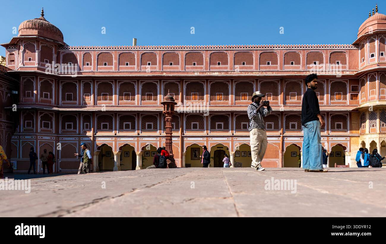 Jaipur, India - 28 dicembre 2025: Pochi visitatori in uno dei giardini del Palazzo della città di Jaipur, senza guardare la macchina fotografica. Foto Stock