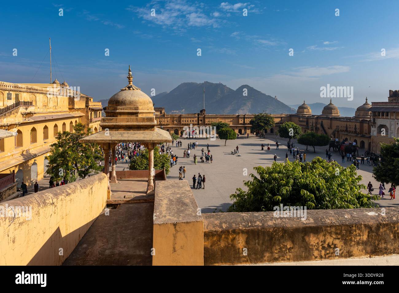 Amer, India - 29 dicembre 2025: Il cortile principale del forte di Amber con molti visitatori. Preso da una terrazza che si affaccia sul cortile in un inverno soleggiato Foto Stock