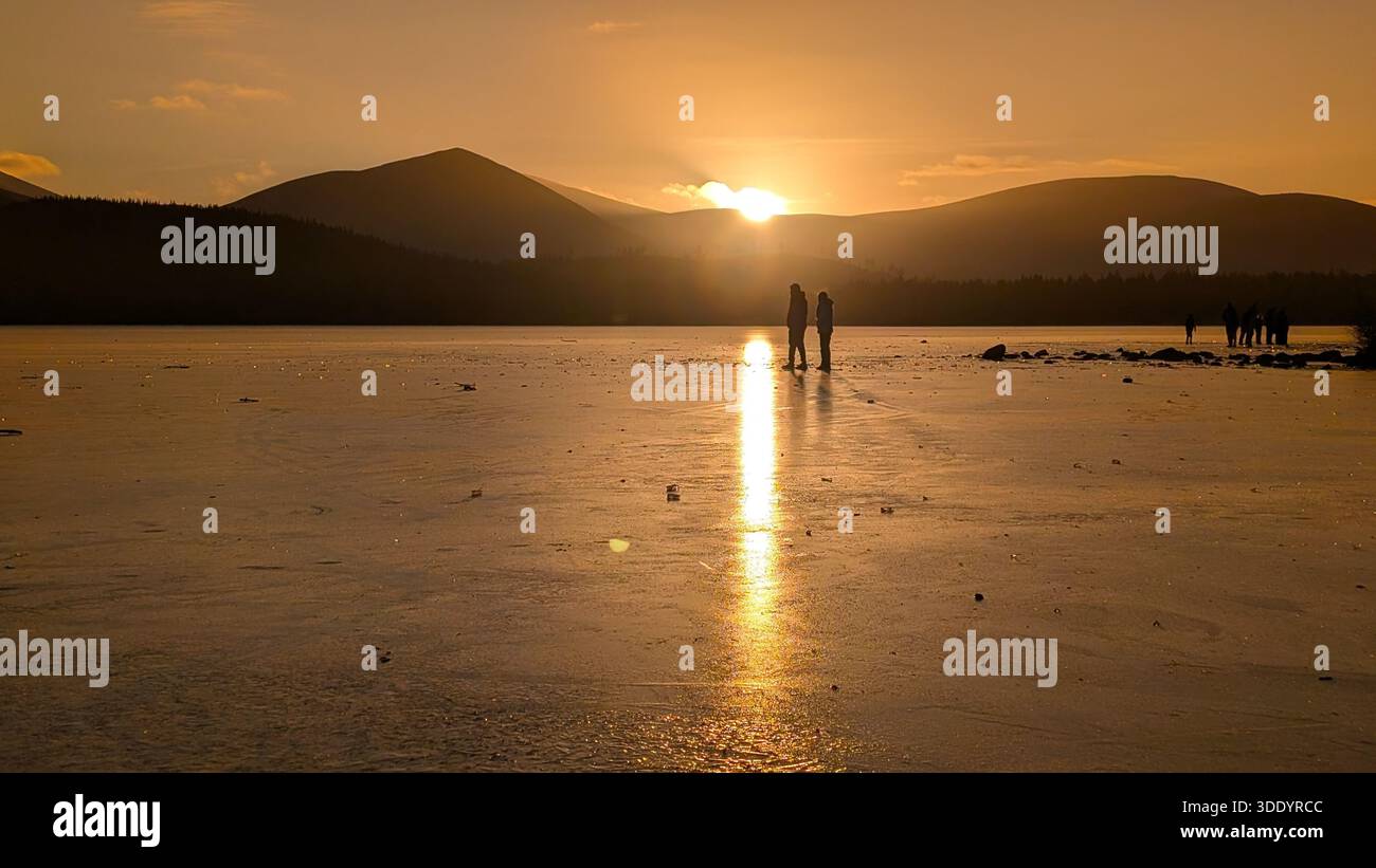 Uno splendido tramonto arancione sulle calme acque autunnali di Loch Linnhe, dove la luce calda si fonde in riflessi tranquilli Foto Stock