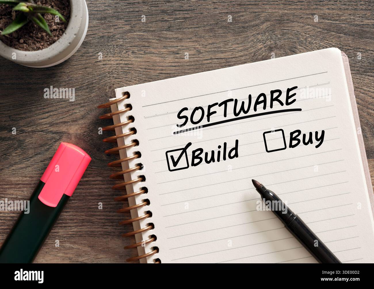 Scegliere di costruire software invece di acquistarne uno. Notebook con opzione di build software selezionata, che rappresenta una decisione strategica per lo sviluppo tecnologico Foto Stock