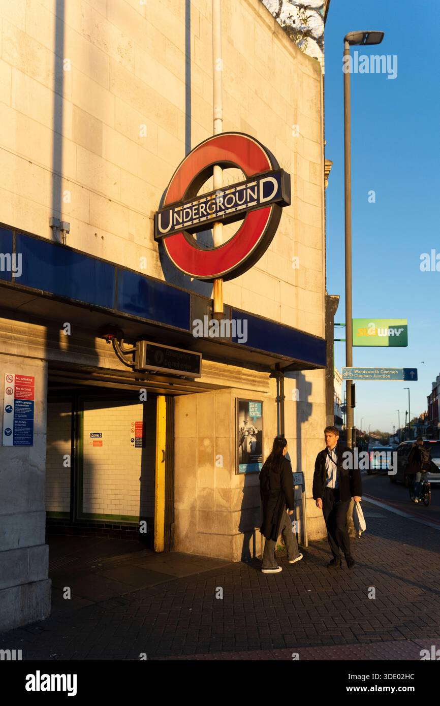 La gente passa accanto all'iconico cartello della metropolitana Foto Stock