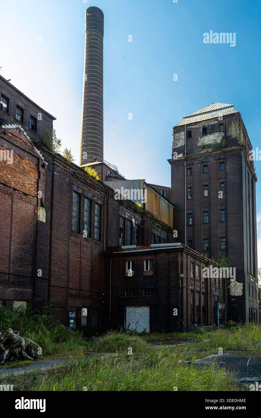 Vista attraverso una scala industriale abbandonata con geometria ripetitiva e superfici usurate Foto Stock
