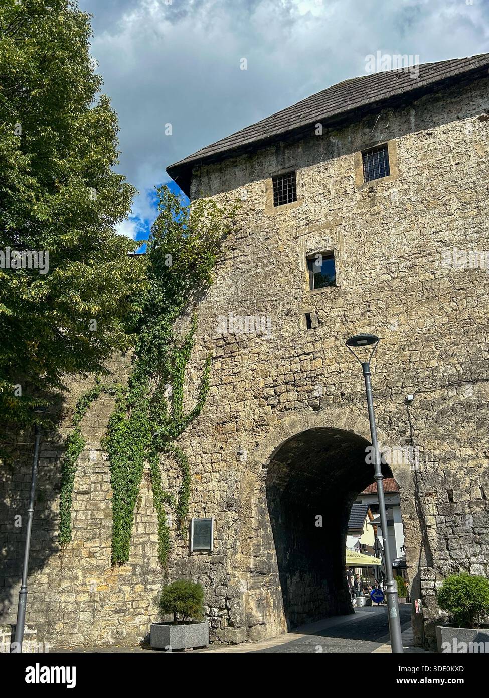 Storico cancello in pietra della città vecchia di Jajce, in Bosnia ed Erzegovina, con mura medievali ricoperte di vegetazione, che catturano l'autentica architettura balcanica - Immagine stock catturata con smartphone