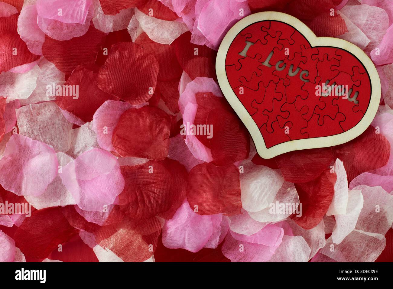 Puzzle in legno "i Love you", a forma di cuore con petali di rosa Foto Stock