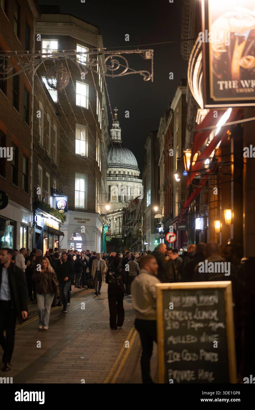 La gente passeggia davanti alla Cattedrale di St. Paul a Londra di notte, godendosi l'atmosfera vibrante della città. Foto Stock