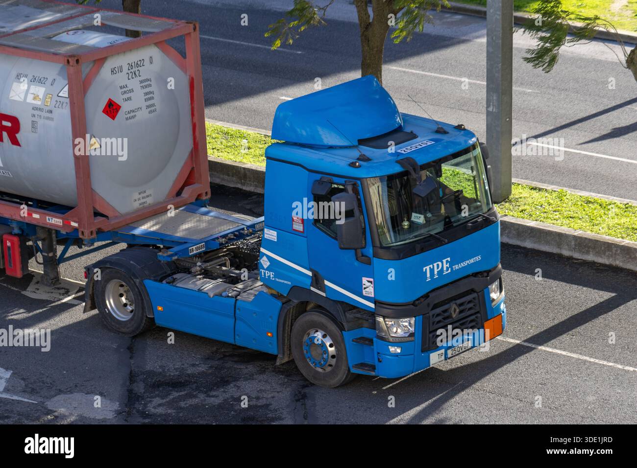 Blue tpe trasporta un camion che trasporta un contenitore serbatoio iso su una strada soleggiata Foto Stock