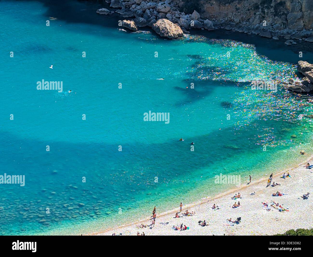 Persone che nuotano a cala Granadella a Javea, in Spagna, in una giornata estiva di sole. Foto Stock