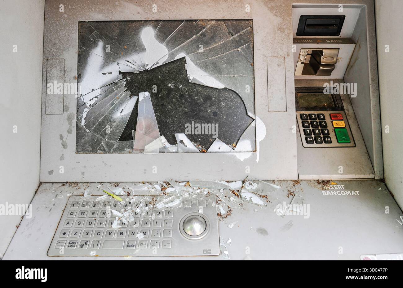 bancomat vandalizzato con schermo rotto e vetro frantumato in un'area pubblica. Il bancomat distrutto simboleggia il decadimento urbano, i danni criminali e la sicurezza Foto Stock