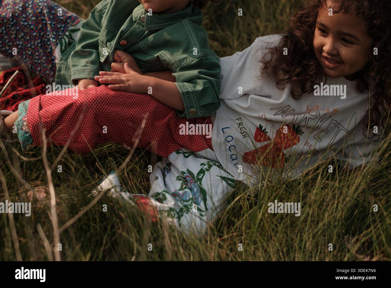 bambini che giacciono insieme nell'erba nelle giornate di sole Foto Stock
