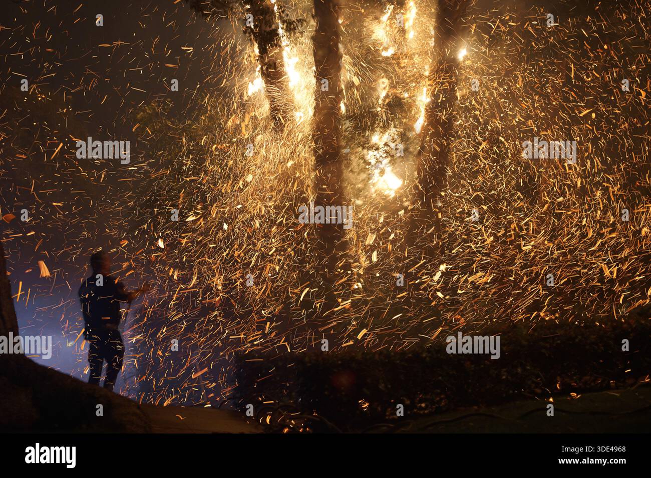 L'uomo maneggia Palms mentre piove gli Embers Foto Stock