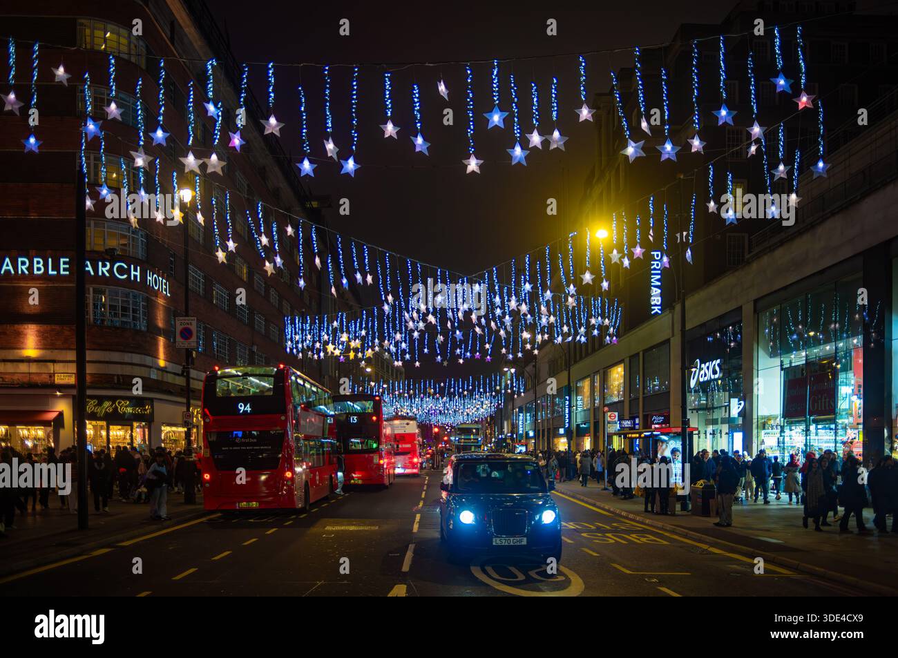 Londra, Regno Unito - 26 dicembre 2025: Trafficata Oxford Street a Londra con luci natalizie e autobus rossi di notte. Foto Stock