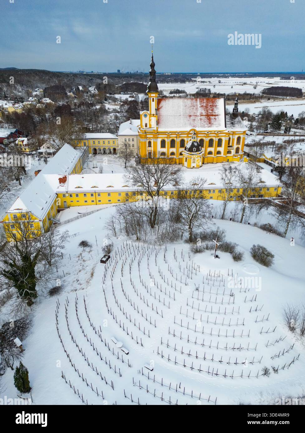 Neuzelle, Germania. 3 gennaio 2026. La chiesa cattolica e il vigneto del monastero di Neuzelle sono ricoperti di neve (vista aerea con un drone). Il monastero di Neuzelle, a circa dieci chilometri a sud di Eisenhüttenstadt, è l'unico monastero cistercense completamente conservato nel Brandeburgo, compresi i terreni, e uno dei pochi complessi monastici non distrutti in Germania e in Europa. Crediti: Patrick Pleul/dpa/Alamy Live News Foto Stock