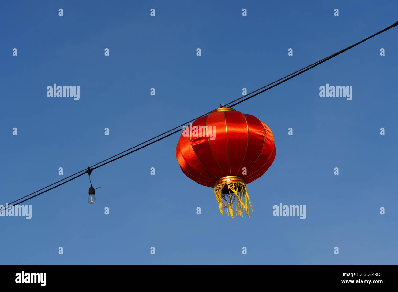Lanterna di carta cinese rossa appesa al cielo blu trasparente – sfondo decorativo minimalista Foto Stock