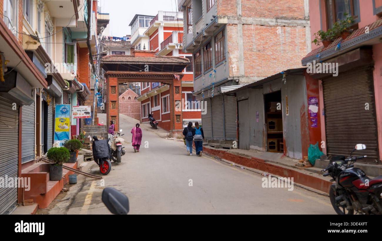 Una strada urbana con negozi chiusi e poche persone in un'atmosfera tranquilla e tranquilla, che cattura un momento di quiete nella vita cittadina. Foto Stock