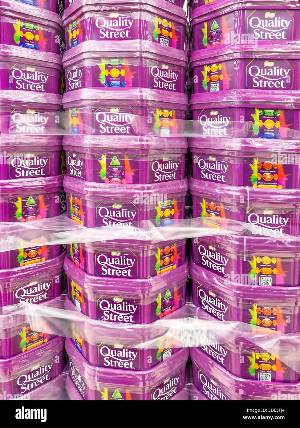 Pile di vasche in plastica di cioccolato di qualità Street rivestite in pellicola di plastica su uno scaffale pronto per la vendita presso christmas tesco Store uk Foto Stock