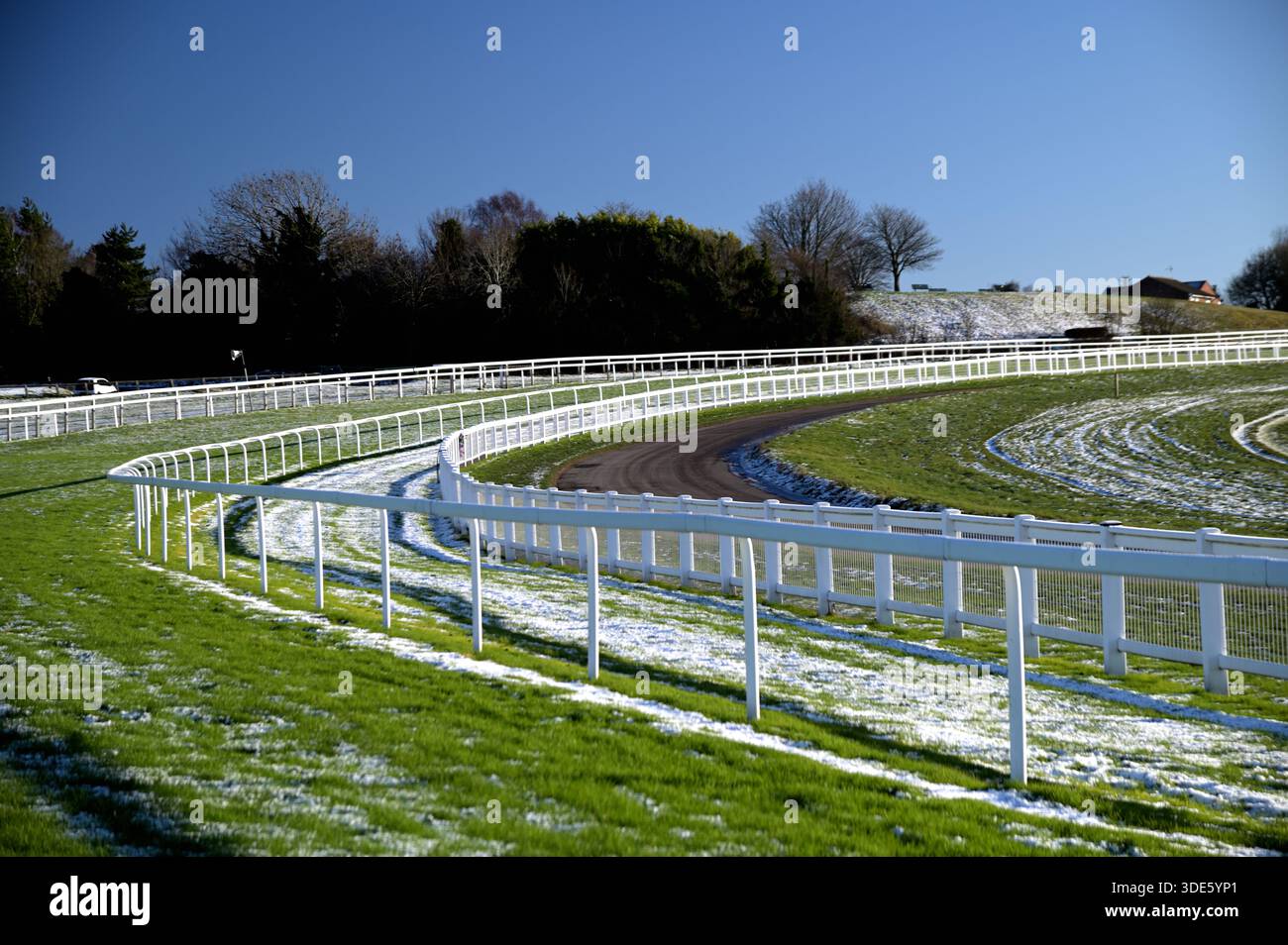 Epsom scende dall'ippodromo in una giornata di inverno soleggiato con neve a terra Foto Stock