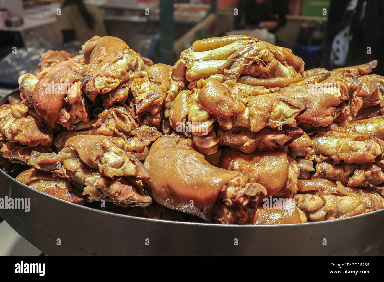 Trotter di maiale brasato a cottura lenta con pelle lucida e carne tenera in ricca salsa di soia, un classico piatto di Street food tailandese. Foto Stock