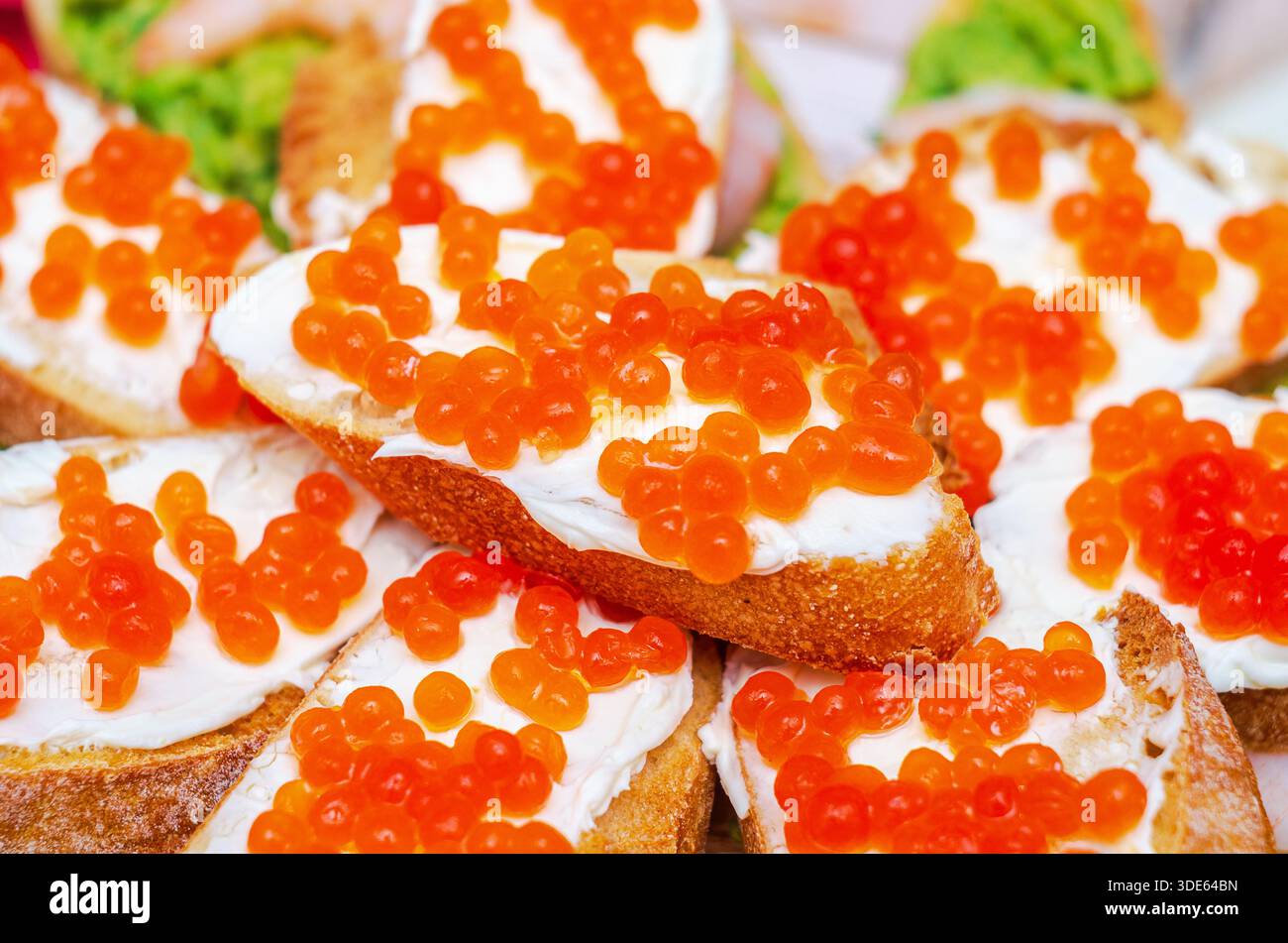 Deliziosi panini a vista conditi con formaggio cremoso e vivace caviale rosso Foto Stock
