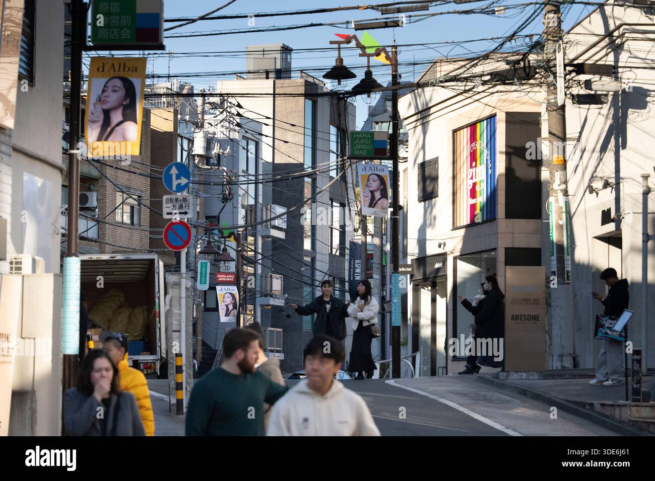 La gente passa accanto ai negozi di Harajuku Jingumae, Tokyo, pubblicizzando prodotti di bellezza e moda. Foto Stock