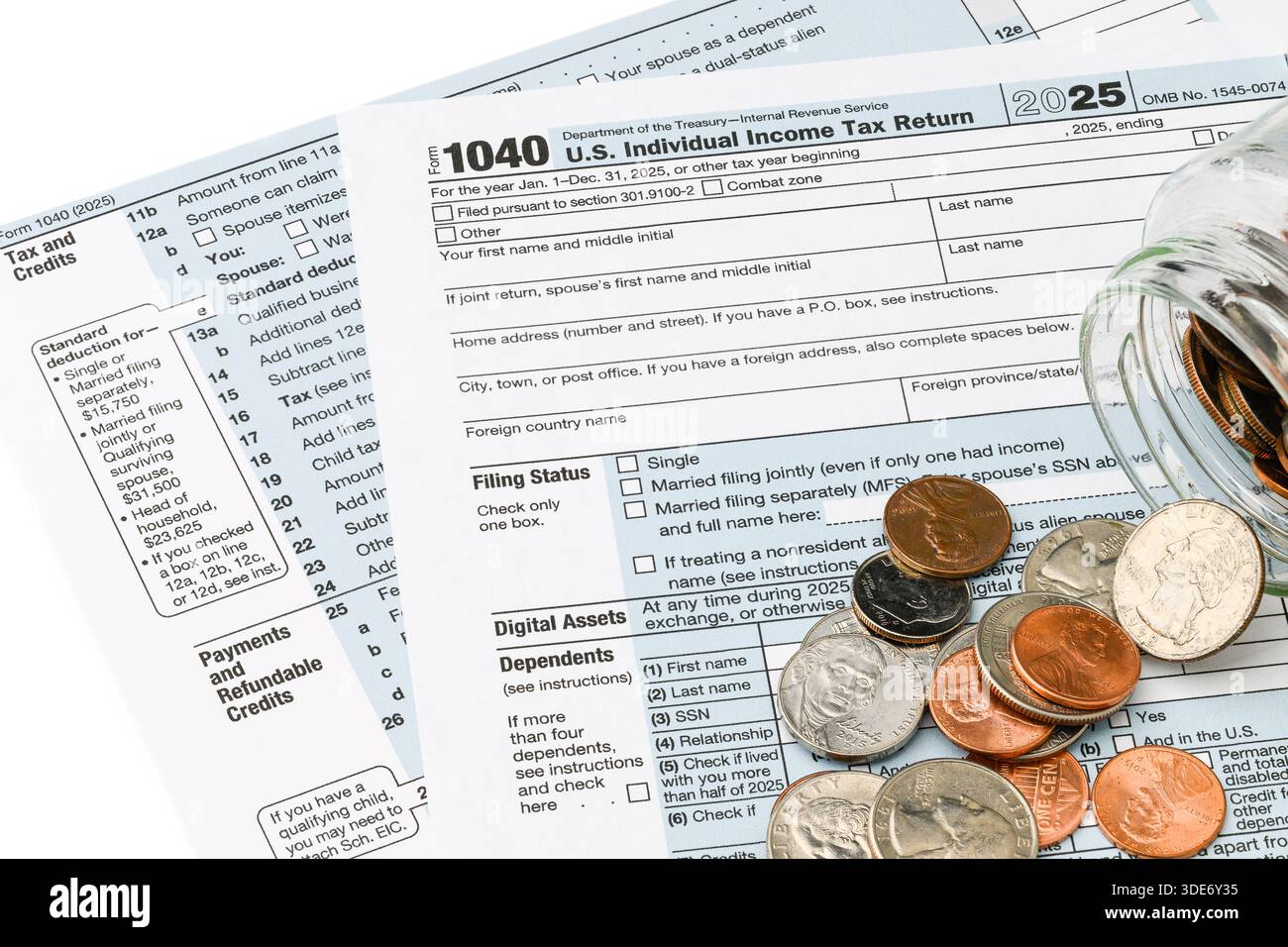 Stati Uniti - 2 gennaio 2026; monete versate dal vaso di vetro attraverso l'IRS Form 1040 per l'anno fiscale 2025 Foto Stock