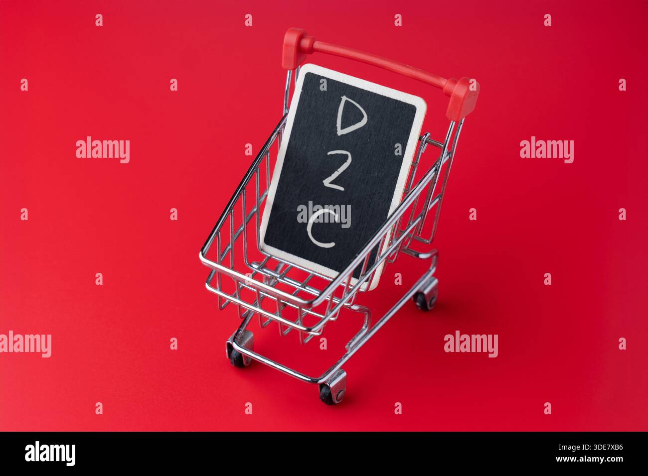Mini carrello con lavagna e testo D2C. Modello di business diretto al consumatore, concetto di e-commerce. Foto Stock