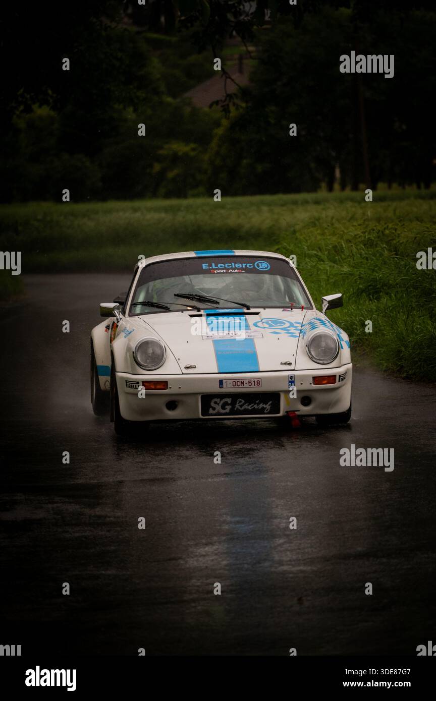 Gare di auto sportive classiche su una strada alpina durante uno storico evento rally nel Vallese, Svizzera, che mette in mostra design retrò e tradizione motoristica. Foto Stock