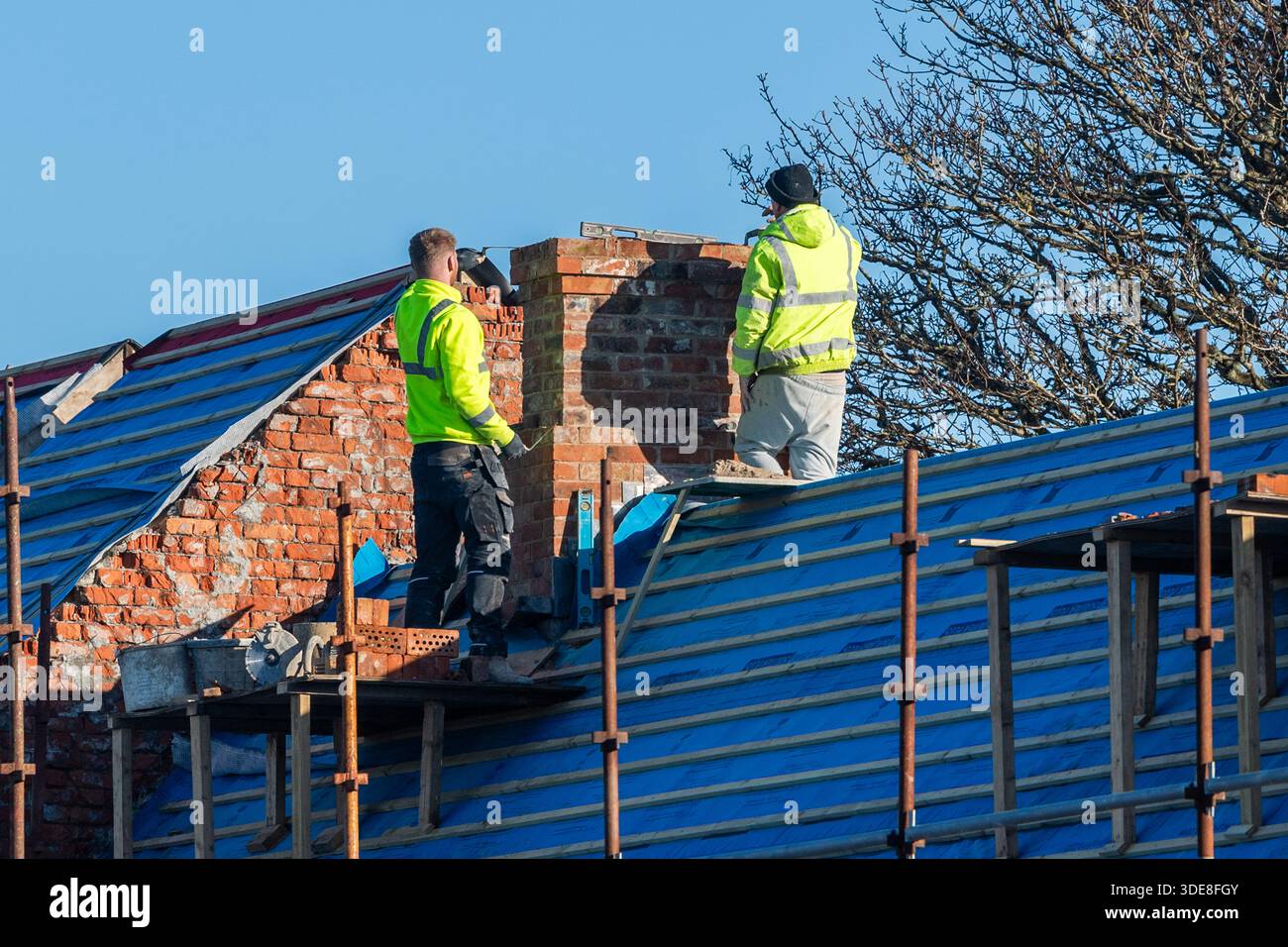 Costruttori che lavorano su un camino a Baltimora, West Cork, Irlanda. Foto Stock