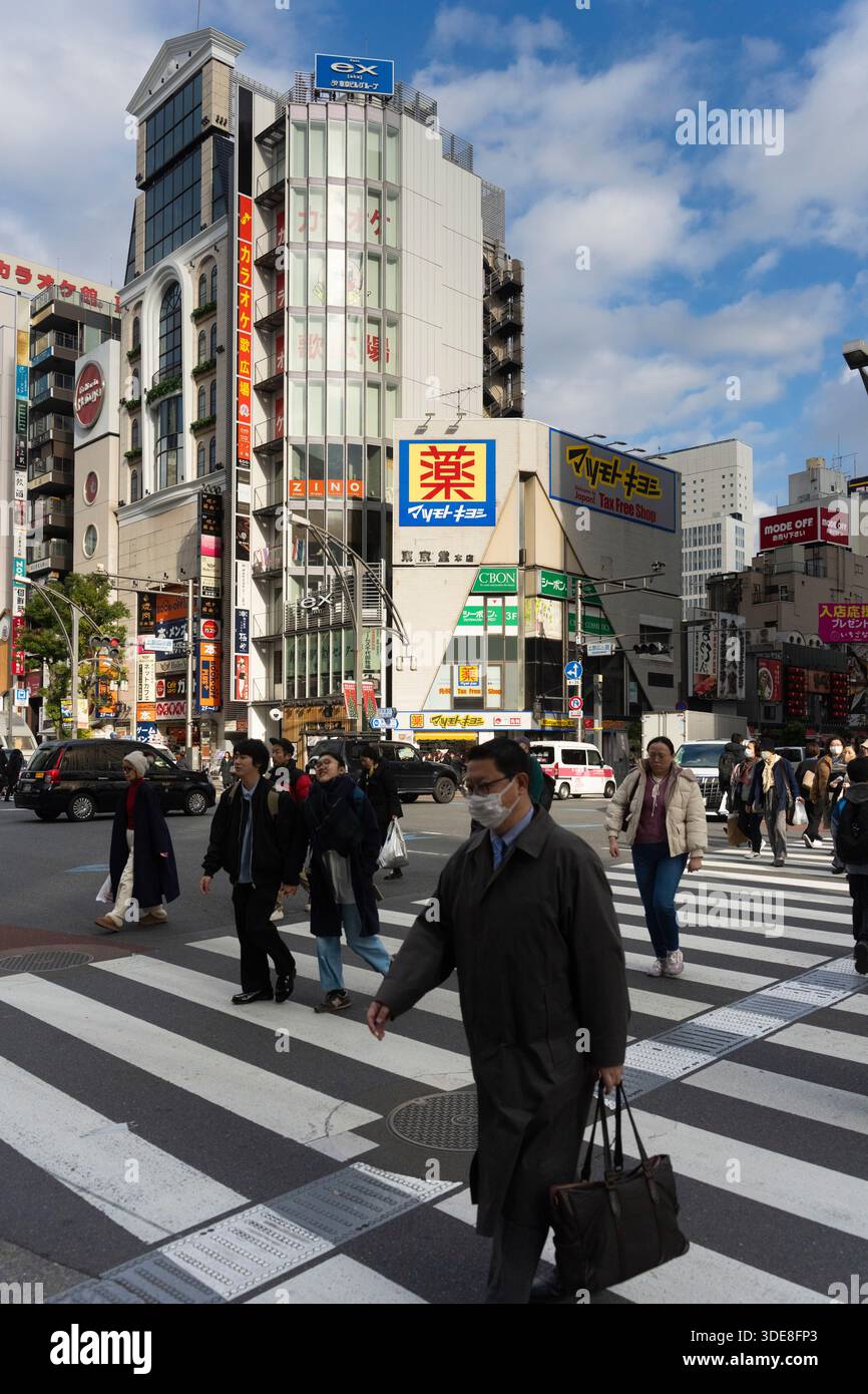 La gente attraversa la strada a Tokyo Foto Stock