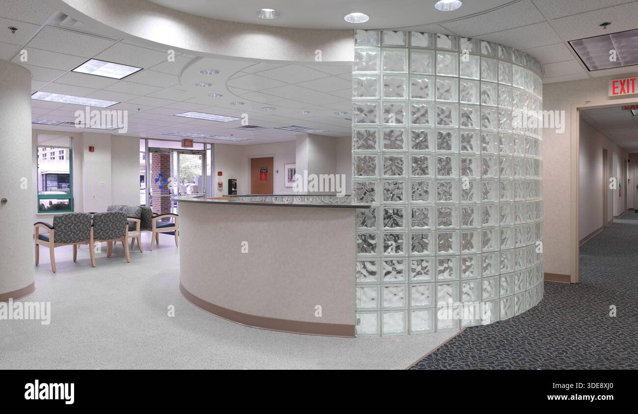 Area reception dell'ufficio medico con parete in mattoni di vetro curvo, Philadelphia USA Foto Stock