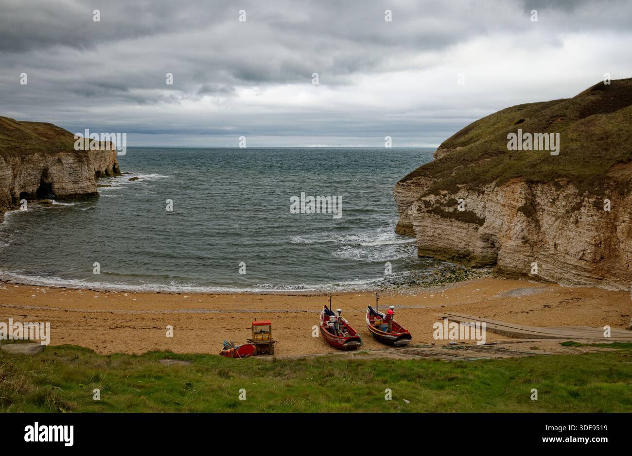 Barche da pesca rimorchiate sulla spiaggia sabbiosa della baia di North Landing a Flamborough Head, East Yorkshire, Inghilterra. Foto Stock