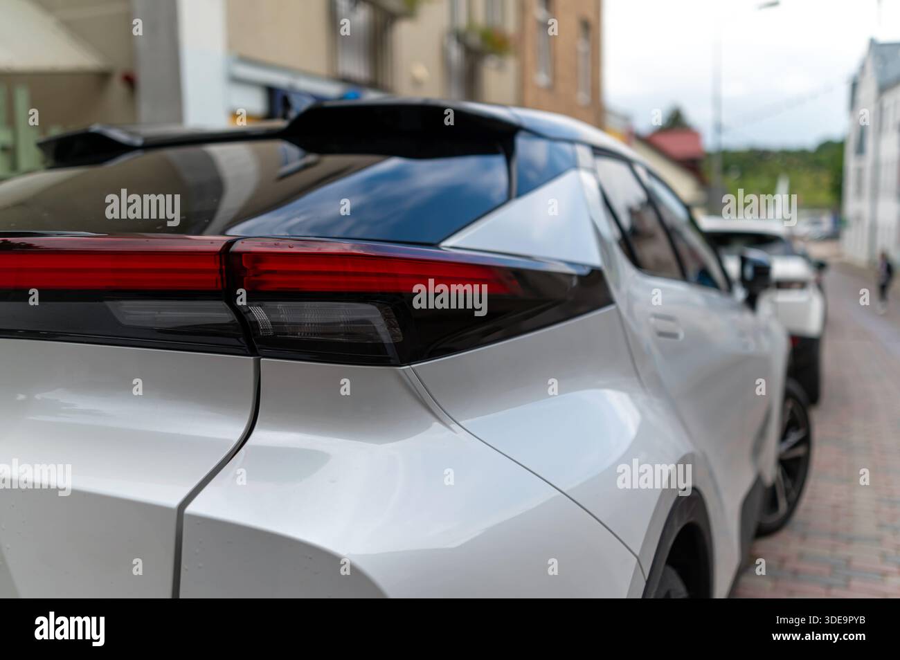 Diverse eleganti auto elettriche sono parcheggiate da vicino in un affascinante ambiente urbano. Foto Stock
