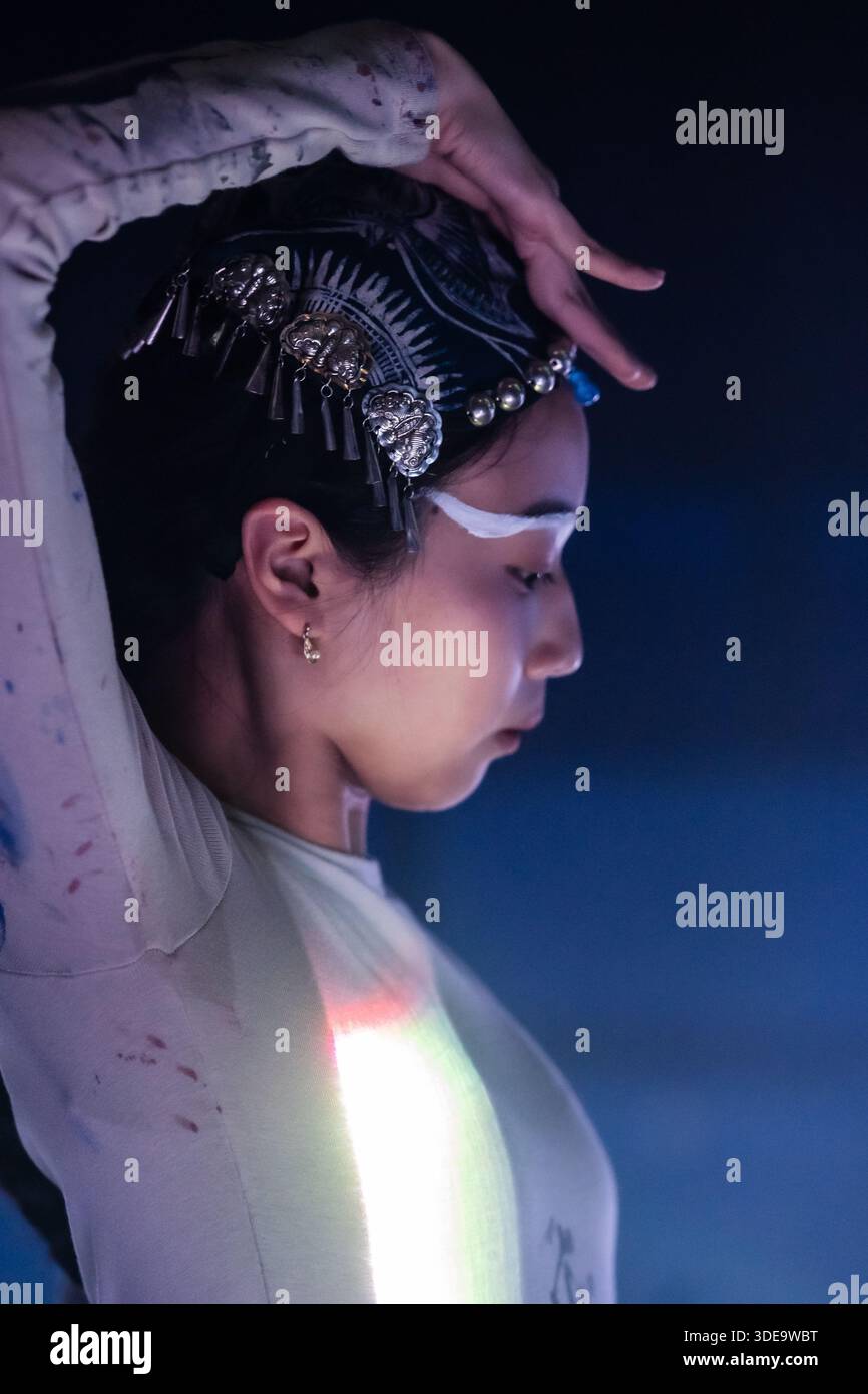 Ritratto artistico di una ballerina asiatica contemporanea in uno spettacolo teatrale. Una fusione poetica di danza cinese e simbolismo culturale con eleganza. Foto Stock
