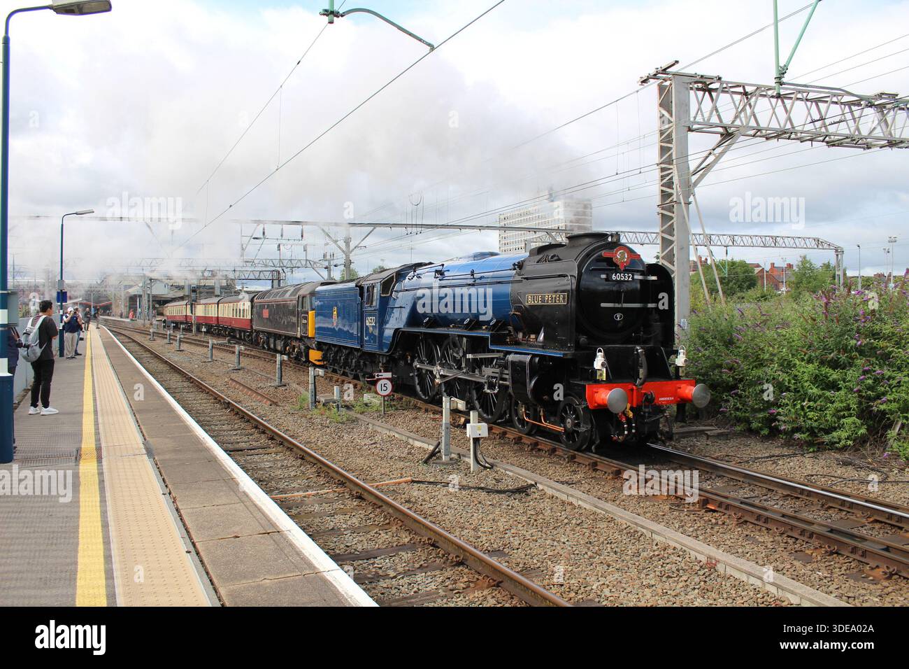 Motore a vapore Blue Peter e classe 57 in treno alla stazione di Crewe Foto Stock