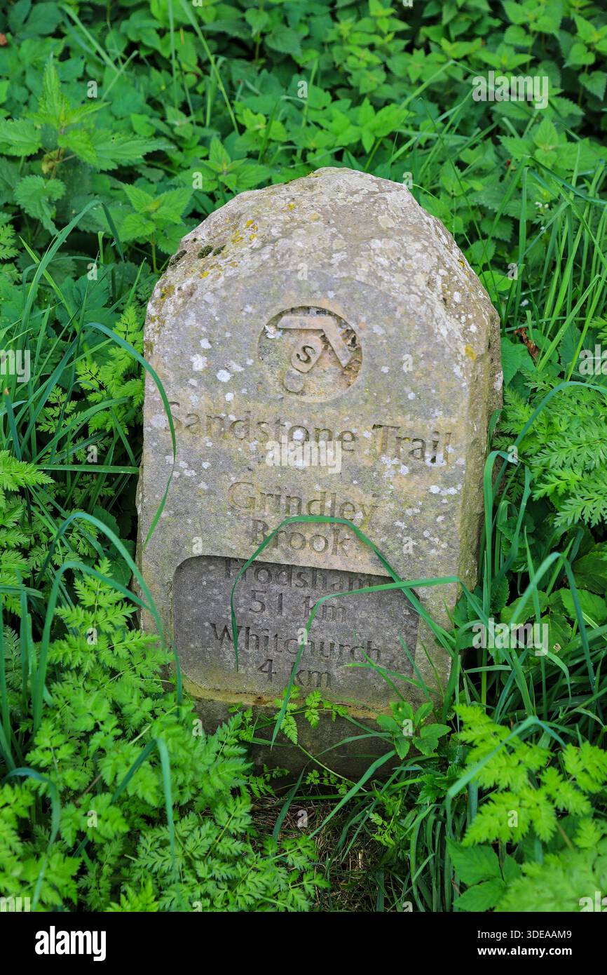 Una pietra miliare che mostra Frodsham 51km e Whitchurch 4km sul Sandstone Trail a Grindley Brook, Shropshire, Inghilterra, Regno Unito Foto Stock