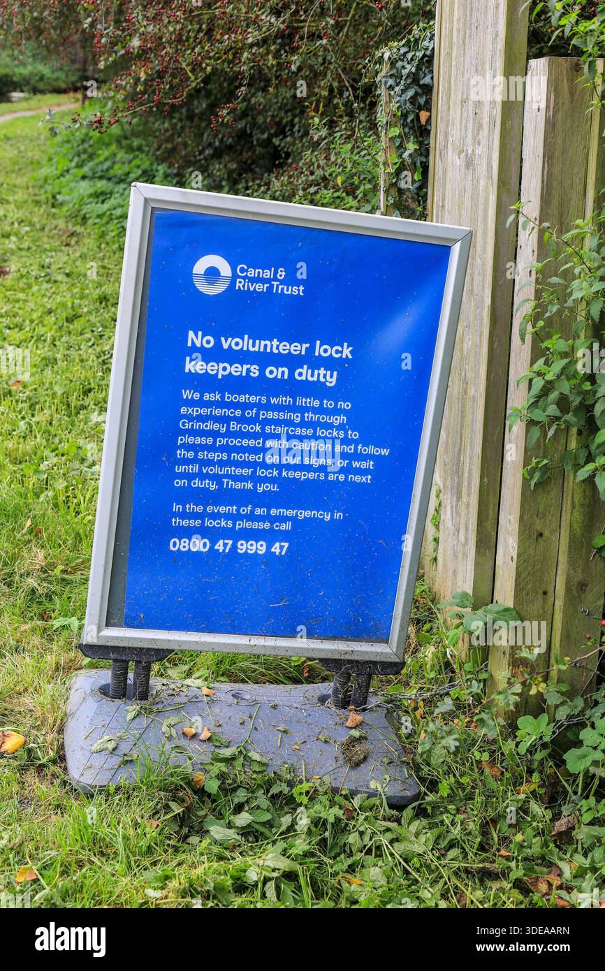 Un cartello emesso dal Canal and River Trust che avvisa i proprietari di imbarcazioni che non ci sono custodi volontari di lucchetti in servizio alle chiuse delle scale di Grindley Brook Foto Stock