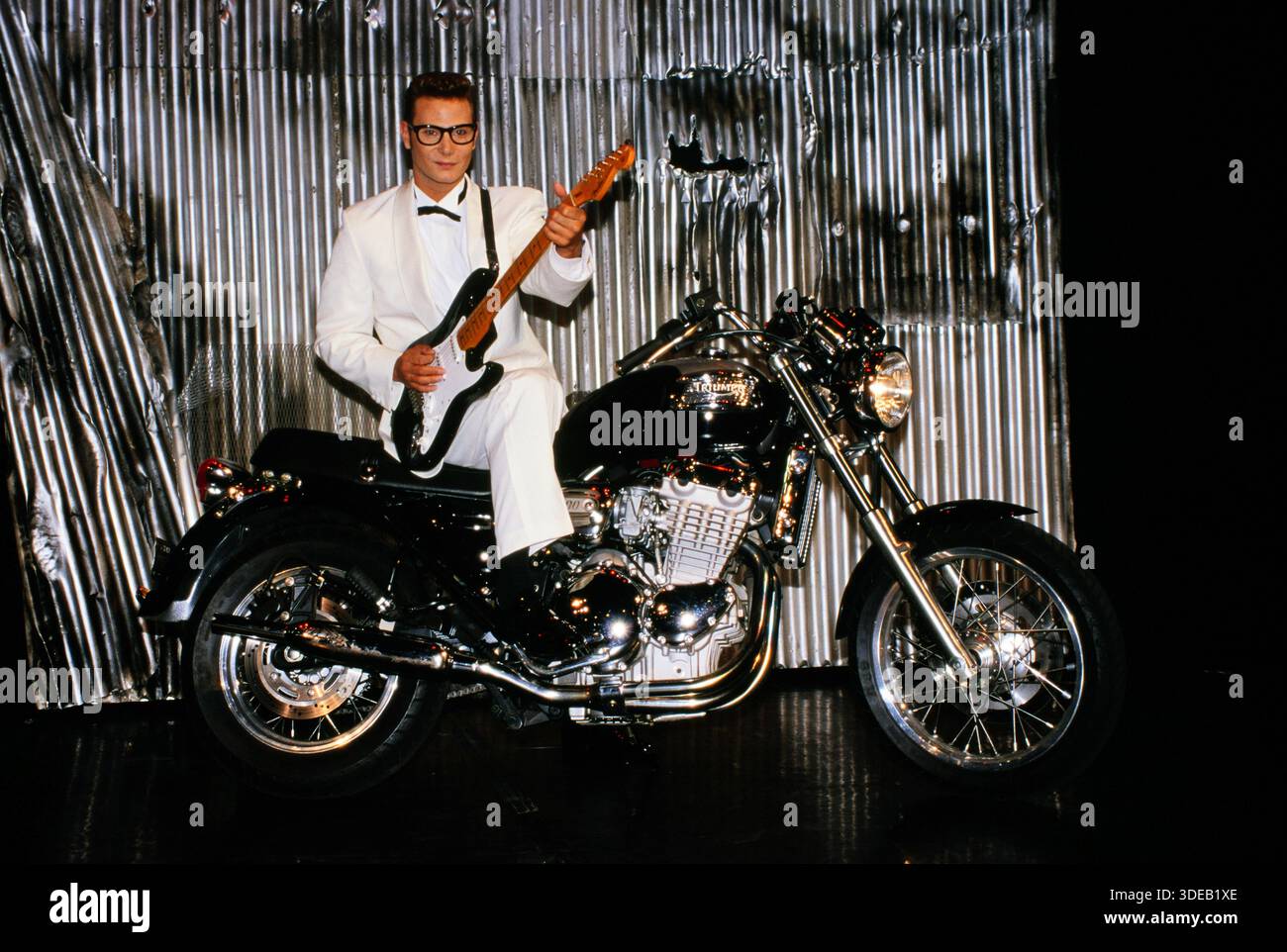Schauspieler und Musiker Fabian Harloff im Musical Buddy, es handelt vom Rock 'n' Roll Musiker Buddy Holly, hier sieht man Hauptdarsteller Fabian Harloff mit Fender Stratocaster Gitarre auf einem Triumpf Motorrad, auf der Bühne des Musical-Theater di Amburgo, 1994. Foto Stock