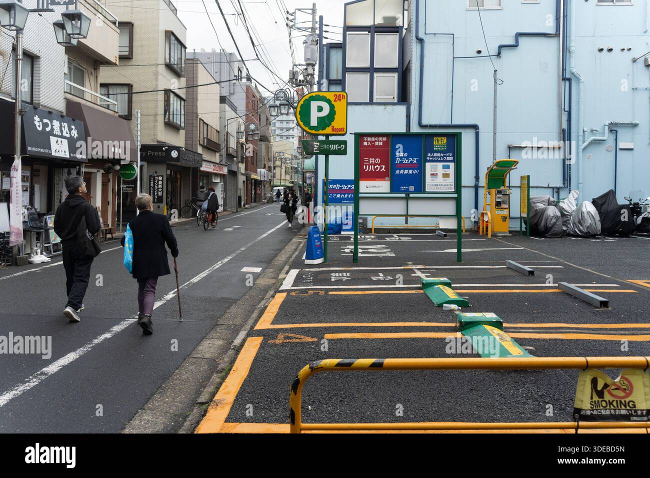La gente passa davanti a un parcheggio a fuori Dori, Tokyo Foto Stock