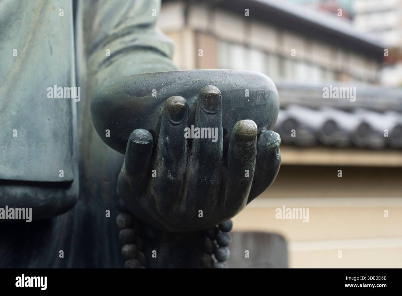 Una statua di un monaco che tiene una ciotola al tempio di Shōgonji, Tokyo, Giappone. Foto Stock
