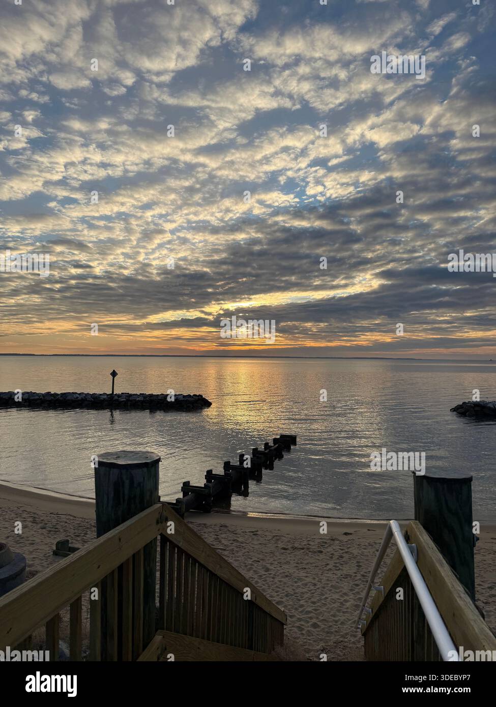 Scale sulla spiaggia che conducono alla baia all'alba - Immagine stock catturata con smartphone