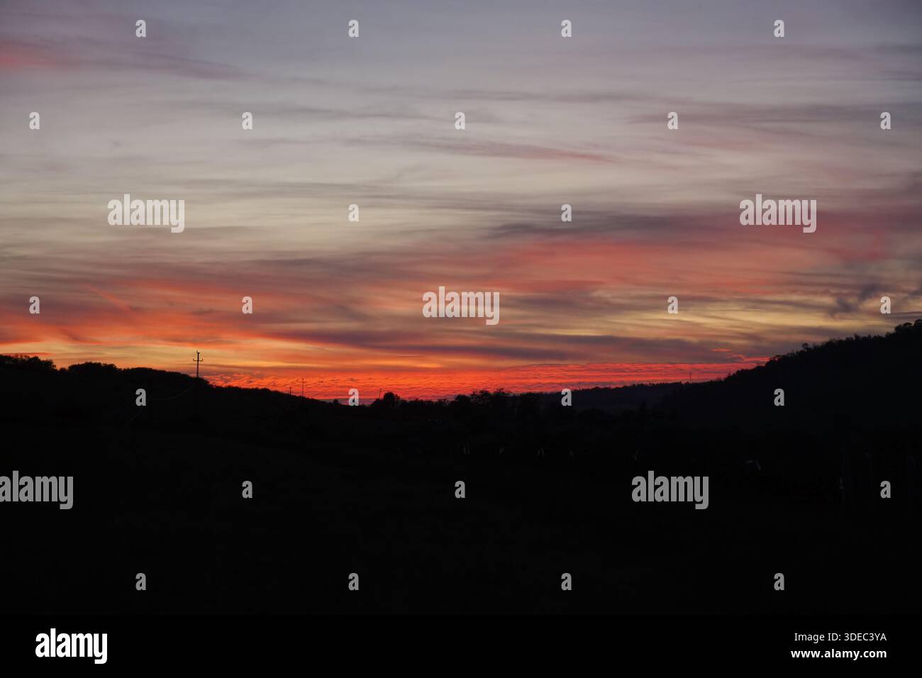 Viaggia in romania transilvania targu mures nuvole rosse e arancioni che illuminano il paesaggio della transilvania al crepuscolo Foto Stock