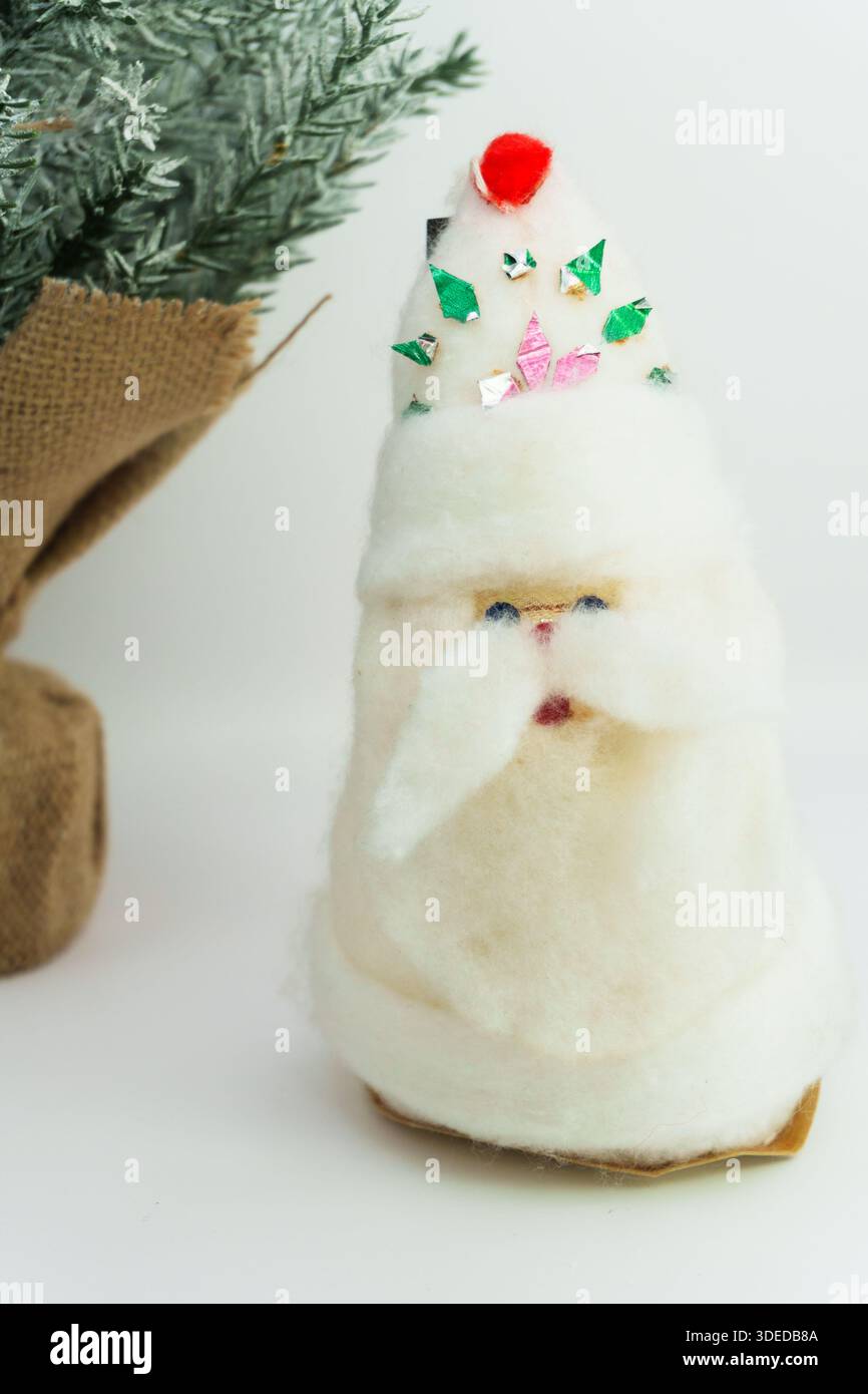 Babbo Natale o Babbo Natale su sfondo bianco, giocattolo di Babbo Natale e alberi di Natale sullo sfondo, felice anno nuovo. Mancia bianca di Babbo Natale Foto Stock