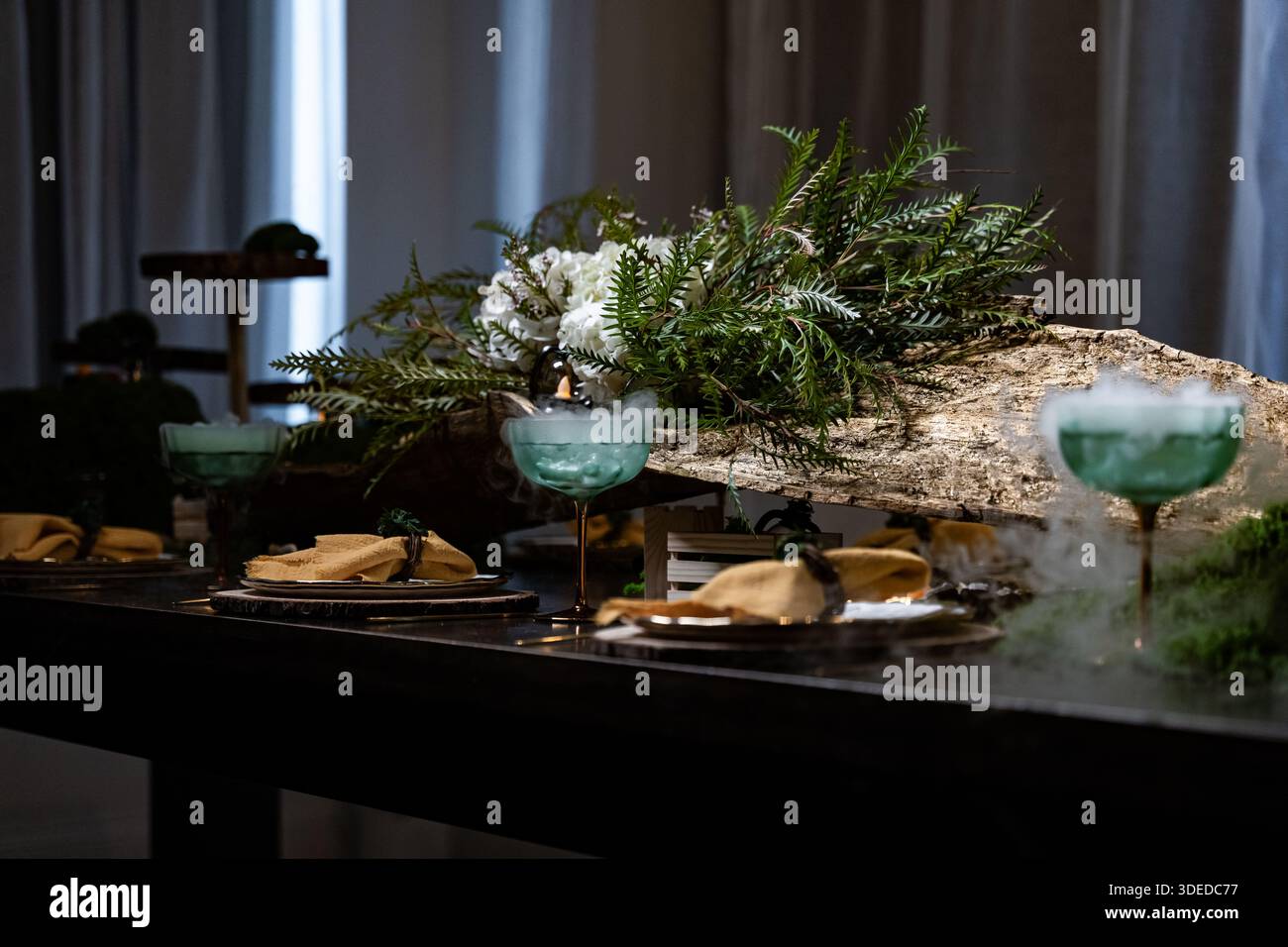 Il tema mistico della foresta è decorare un tavolo festivo per il catering. Fumo intenso proveniente da un bicchiere su un tavolo fisso Foto Stock