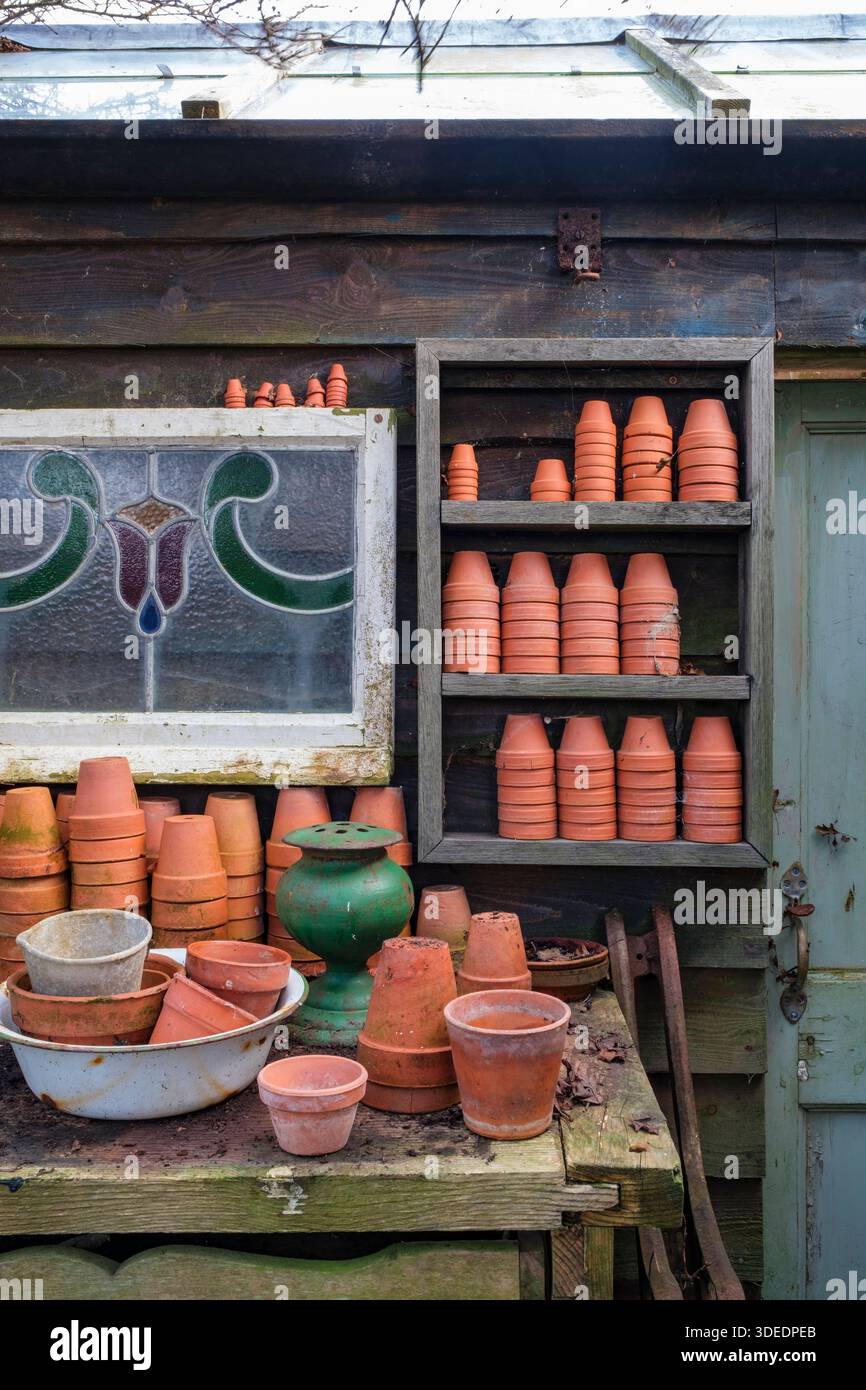 Pentole di terracotta impilate all'esterno del capannone per vasi nel giardino d'inverno Foto Stock